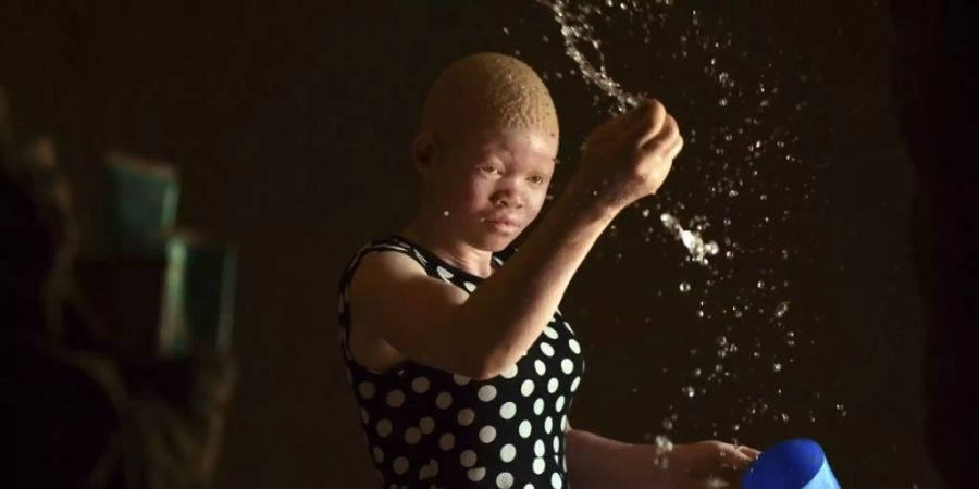 Catherine Amidu befeuchtet ihren sandigen Hüttenboden in Machinga, Malawi. Als Albina muss sie um ihr Leben fürchten, da Körperteile von Menschen wie ihr als glückbringend gehandelt werden. (Archivbild Februar 2020)