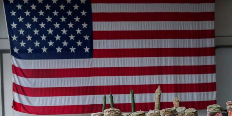 US-Soldaten während einer militärischen Zeremonie in den Storck-Barracks vor einer Flagge der Vereinigten Staaten von Amerika. Foto: Nicolas Armer/dpa