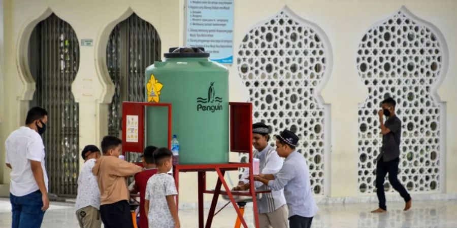 Container zum Hände-Desinfizieren vor einer Moschee