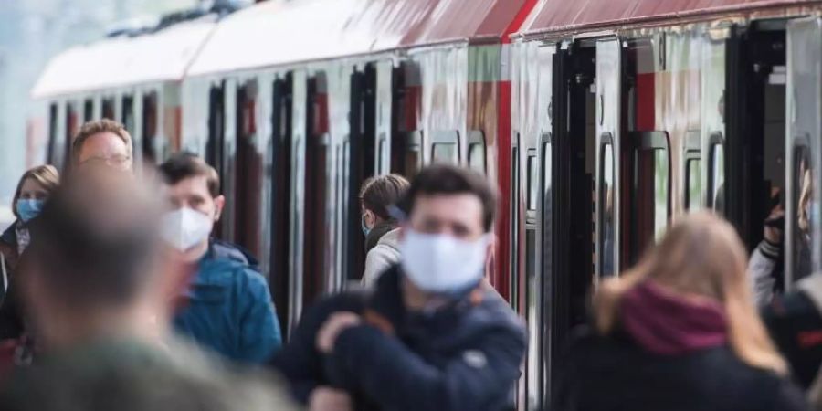 Fahrgäste mit Mund-Nasen-Schutz in einem S-Bahnhof in Hamburg. Foto: Daniel Bockwoldt/dpa