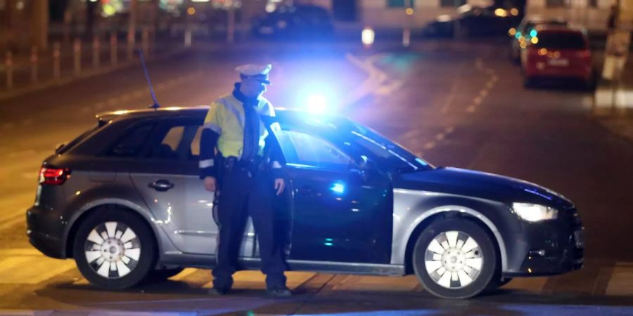 Ein Polizist steigt gerade aus einem Auto aus. (Symbolbild)