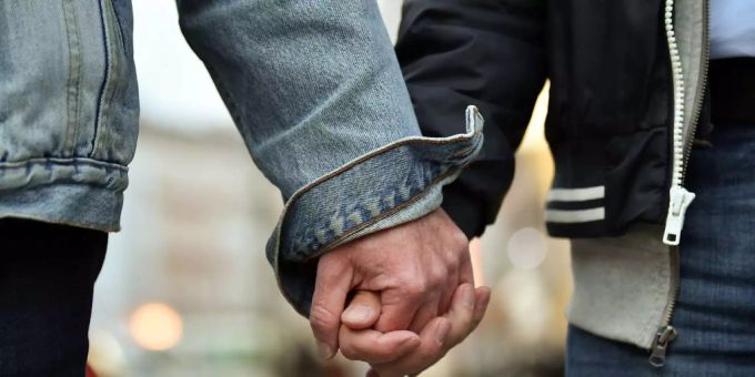 Zwei Männer halten Händchen. internationaler Tag gegen Homo-, Bi-, Inter- und Transphobie