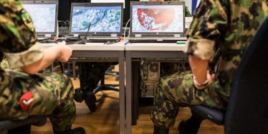 Soldaten sitzen vor Laptops bei einer Simulationsübung.