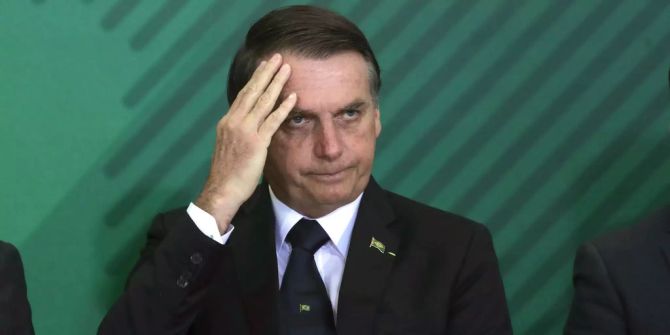 Jair Bolsonaro kratzt sich am Kopf.