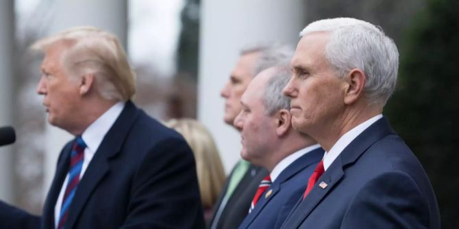 Mike Pence steht hinter Donald Trump.