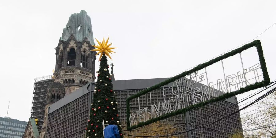 Ein Mann verlegt Stromleitungen am Weihnachtsmarkt am Breitscheidplatz.