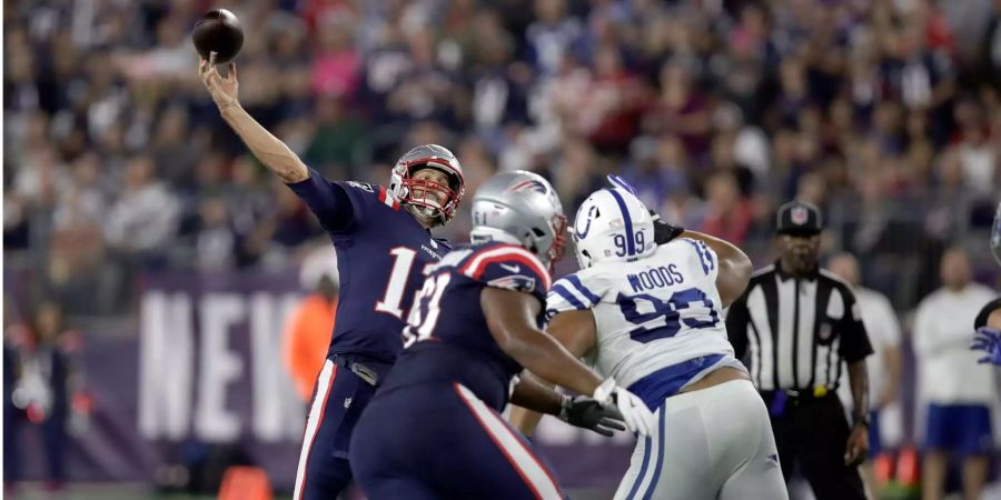 New England Patriots Quarterback Tom Brady (l), wirft einen Touchdown-Pass zu Josh Gordon (nicht im Bild), während Indianapolis Colts Defensive Tackle Al Woods (99) angreift in der zweiten Hälfte des Spiels.