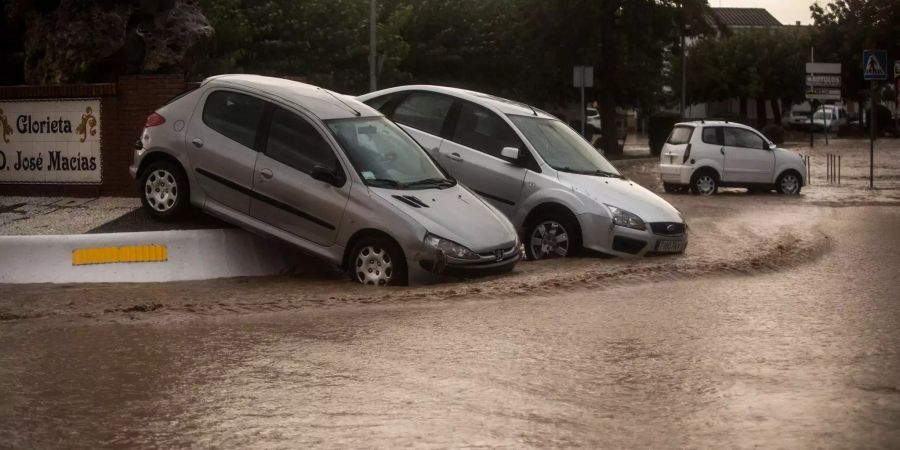 Autos stehen an einer überfluteten Strasse in der spanischen Provinz Malaga.