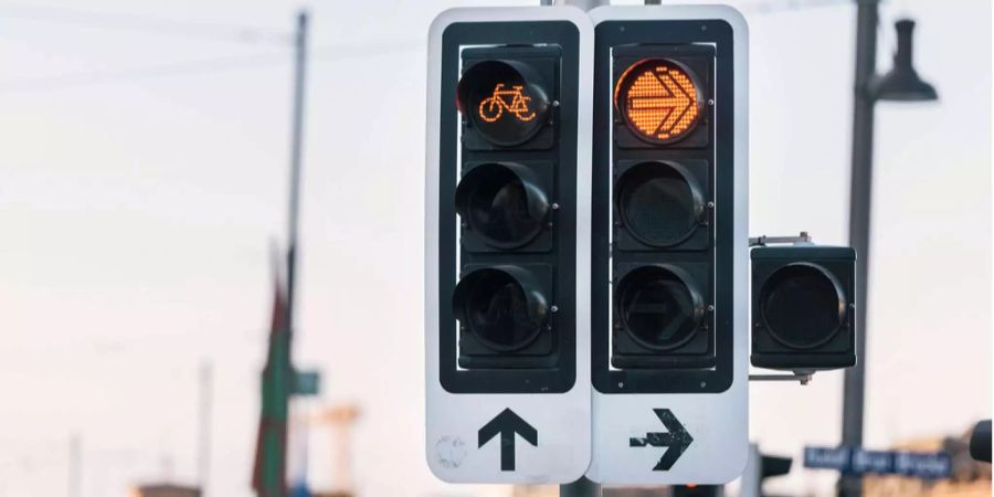 Eine Verkehrsampel auf Rot für Autofahrer und Fahrradfahrer in Zürich.