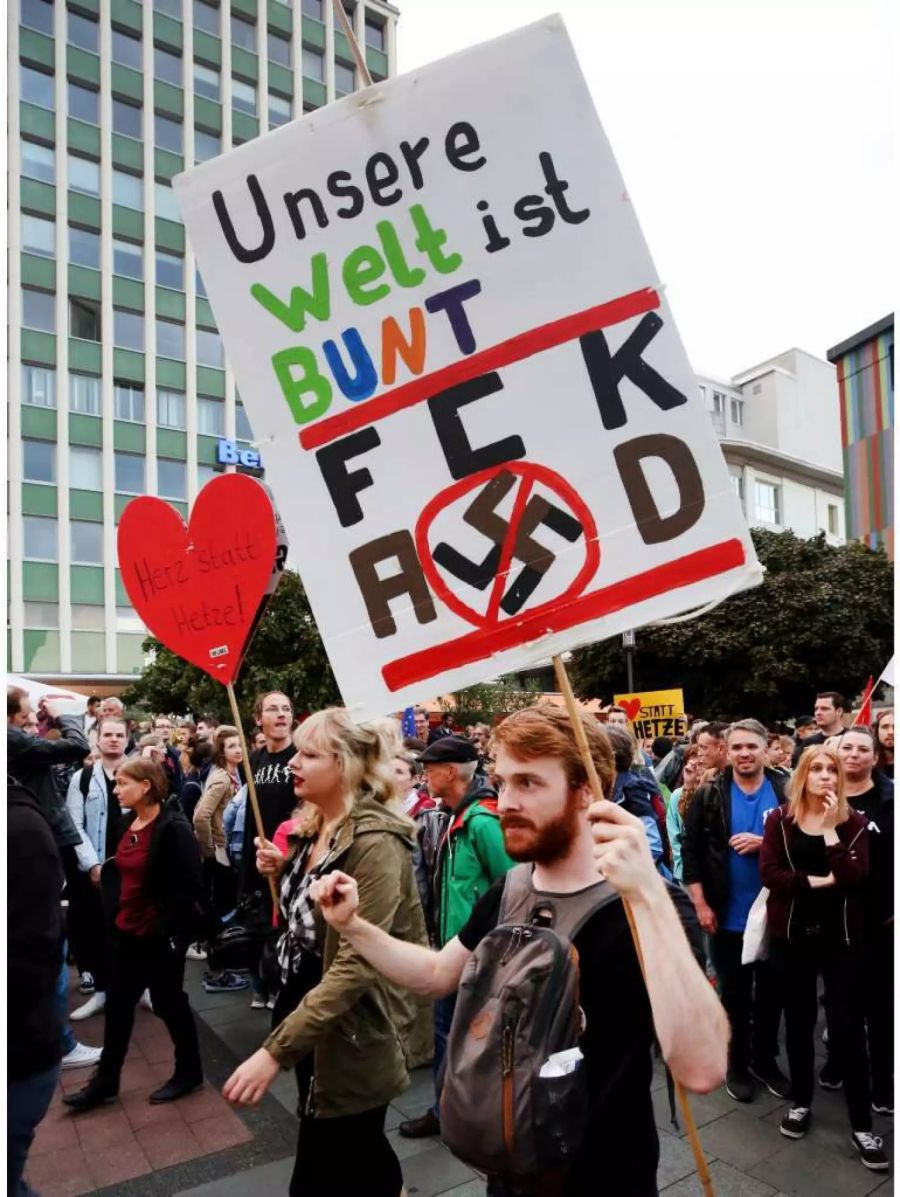 Demonstranten protestieren unter dem Motto «#WIRSINDMEHR - Aufstehen gegen rechte Hetze» mit einem Plakat «Unsere Welt ist bunt».