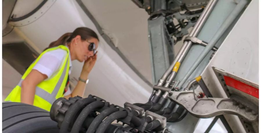 Pilotin Delie kontrolliert während einem Zwischenhalt die Pneus und Technik.