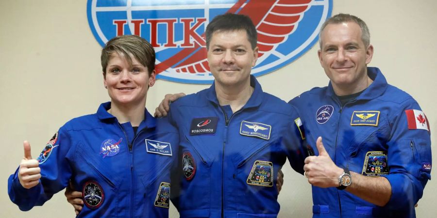 Anne McClain (l), Astronautin aus den USA, steht neben Oleg Kononenko (M), Kosmonaut aus Russland, und David Saint Jacques, Astronaut aus Kanada, während einer Pressekonferenz.