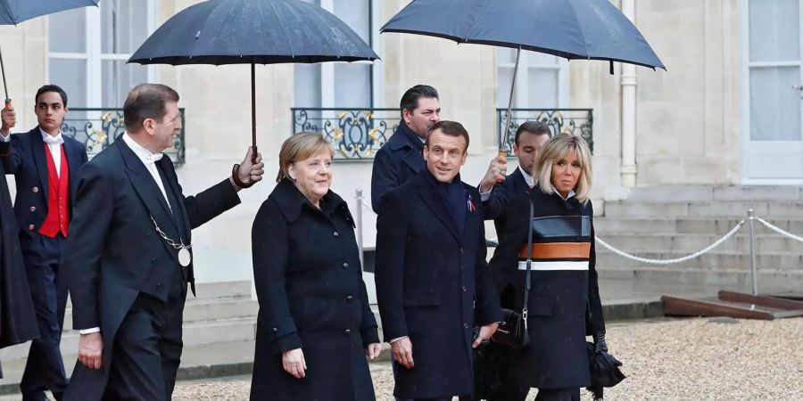 Angela Merkel (Zweite von links), Emmanuel Macron (Mitte) und seine Frau Brigitte (rechts).