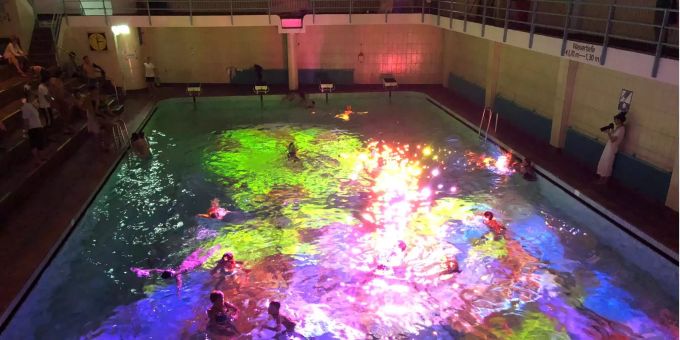 Menschen schwimmen im Hallenbad Hirschengraben und geben sich im farbigen Licht als Koralle aus. Menschen schwimmen im Hallenbad Hirschengraben und geben sich im farbigen Licht als Koralle aus.