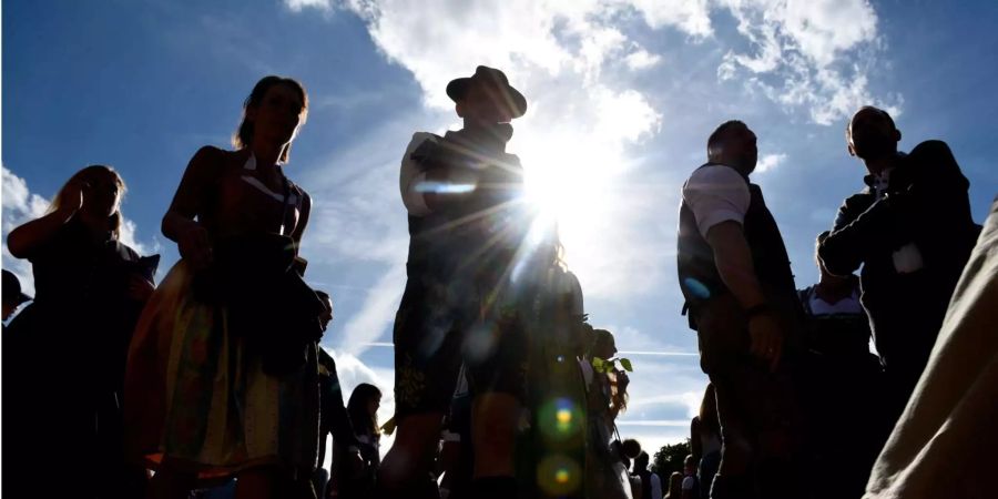 Oktoberfestbesucher laufen über die Wiesn.