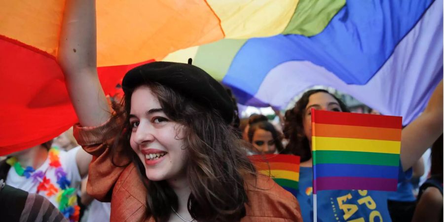 Eine Frau geht unter einer riesigen Regenbogen-Fahne während der Gay-Pride-Parade in Bukarest.