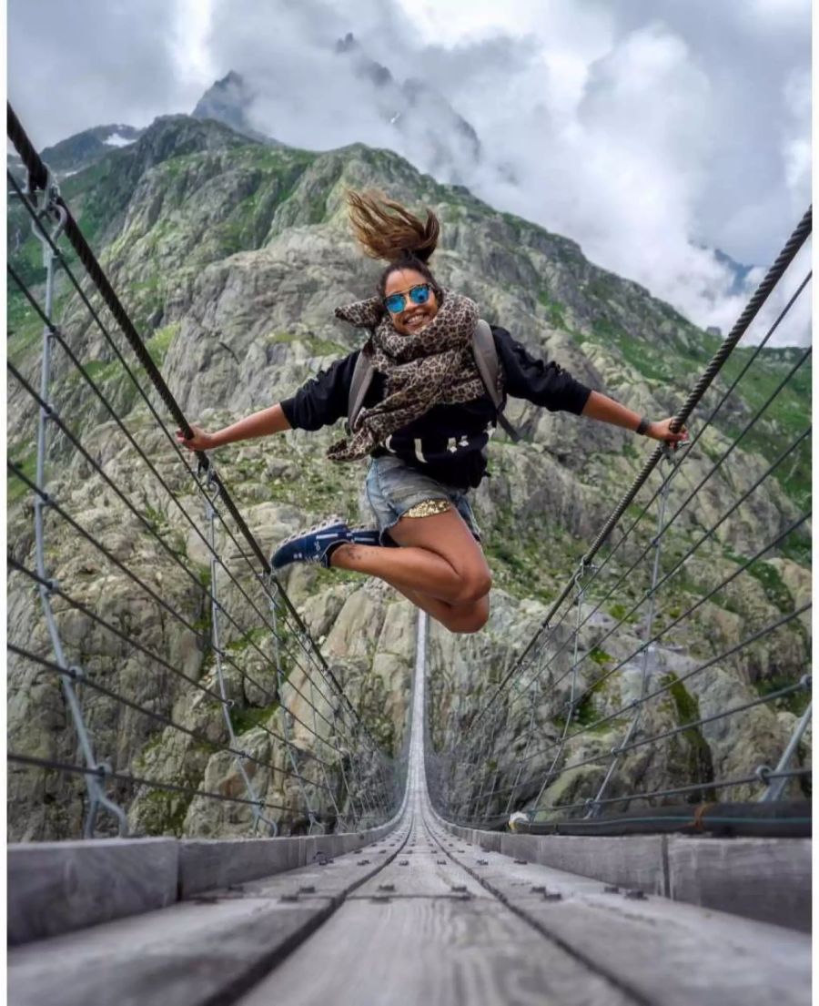 Fabienne Louves springt während ihrem Ausflug auf einer Brücke.