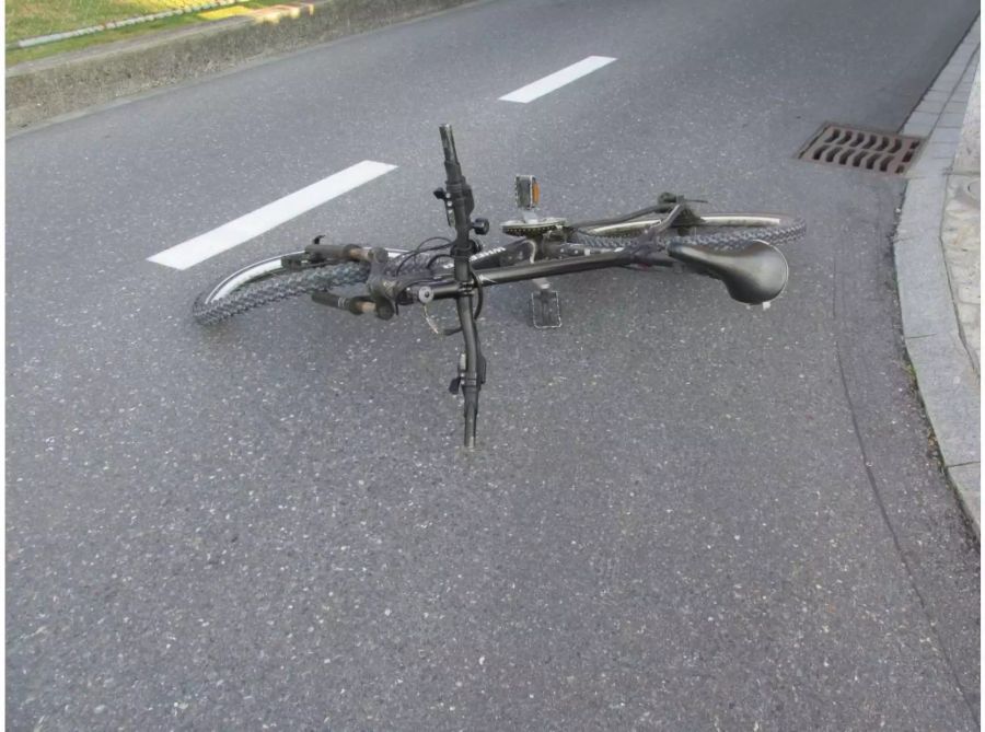 Schwarzes Velo mit verbogenem Vorderreifen auf der Strasse - zvg Kantonspolizei Glarus