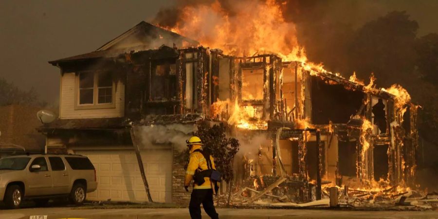 Ein Feuerwehrmann läuft neben einem brennenden Haus in Santa Rosa (Kalifornien, USA) vorbei.