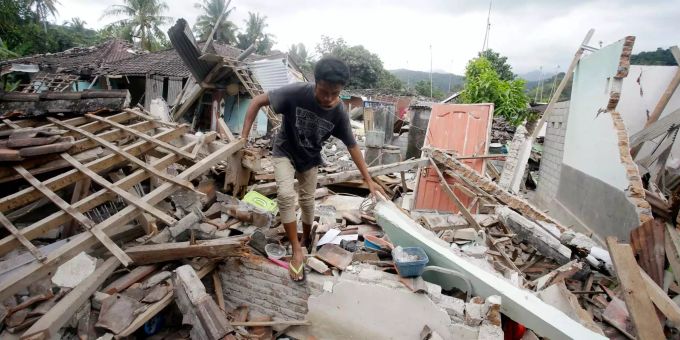 Ein Mann geht über die Trümmer eines vom Erdbeben zerstörten Hauses auf Lombok (IND). Ein Mann geht über die Trümmer eines vom Erdbeben zerstörten Hauses auf Lombok (IND).