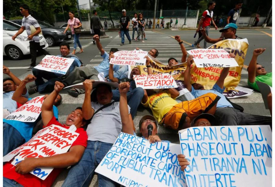 In Manila demonstrieren Menschen gegen die Abschaffung von veralteten Jeepneys.