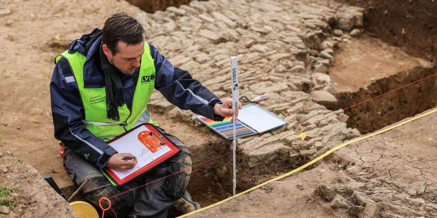 Ein Archäologe kartographiert im Frühjahr 2023 nach Grabungen in Xanten die Mauern eines römischen Gebäudes nahe dem ehemaligen Legionslagers Vetera Castra.