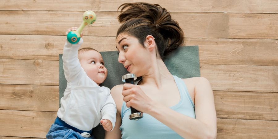 Frau mit Baby auf Fitnessmatte