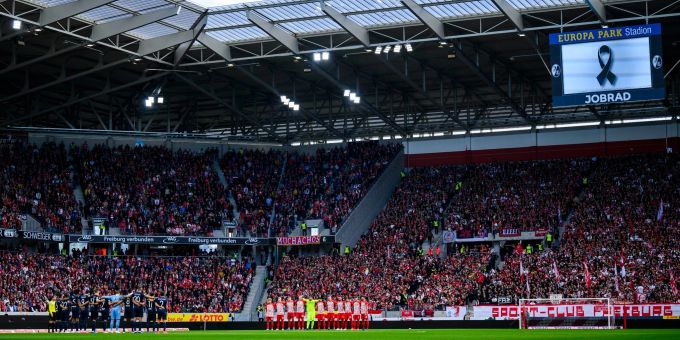 Die Spieler des SC Freiburg und des VfL Bochum stehen bei einer Schweigeminute zusammen. Bundesliga