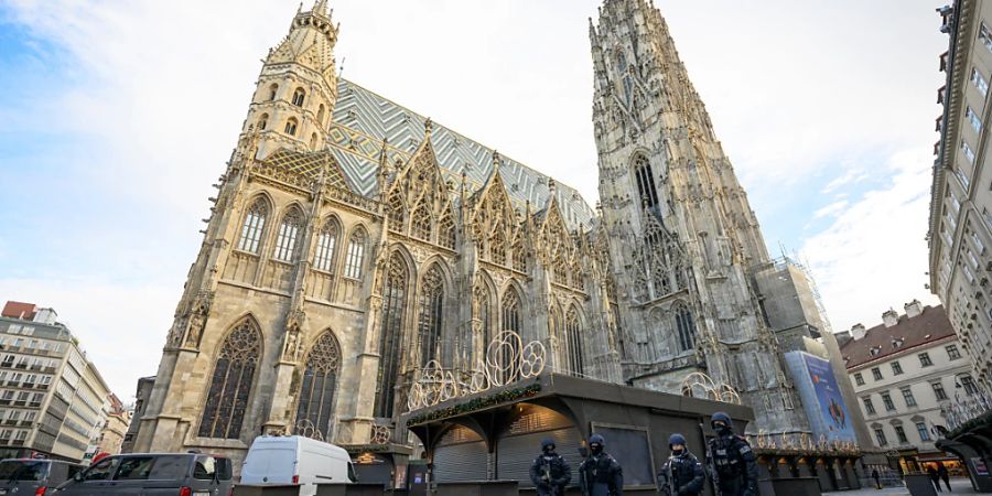 Polizisten stehen nach Hinweisen auf einen möglichen Anschlagsplan einer islamistischen Gruppe vor der Domkirche St. Stephan. Foto: Max Slovencik/APA/dpa