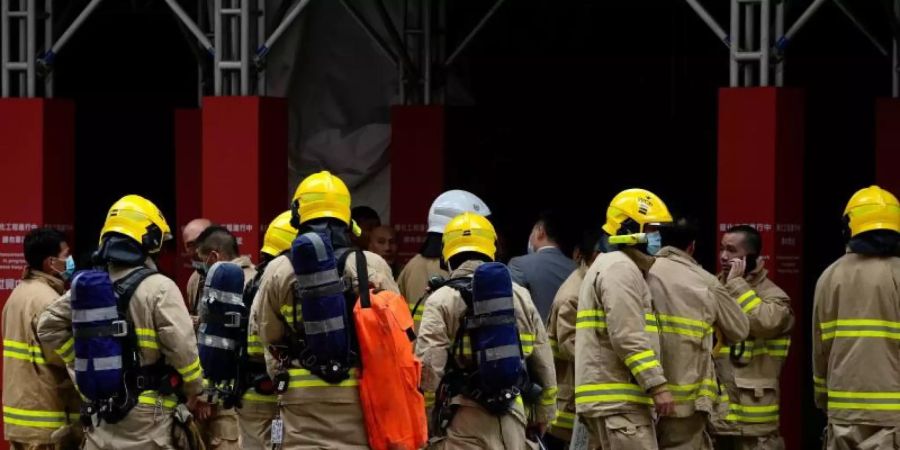 Feuerwehrleute am Einsatzort vor Hongkongs World Trade Centre. Foto: Kin Cheung/AP/dpa