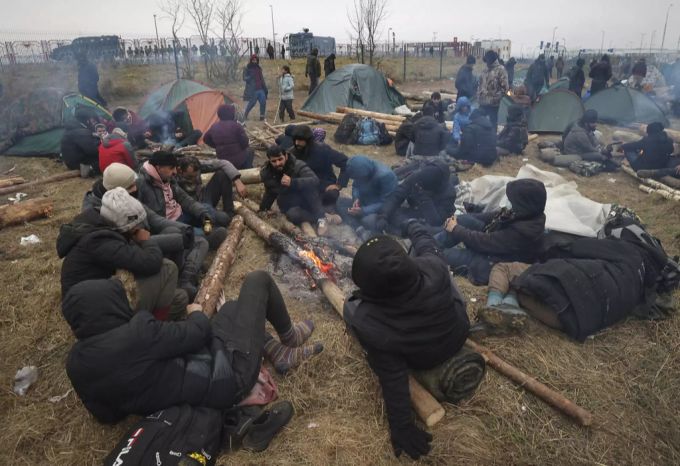 Migranten wärmen sich an einem Feuer an der Grenze zu Polen. belarus