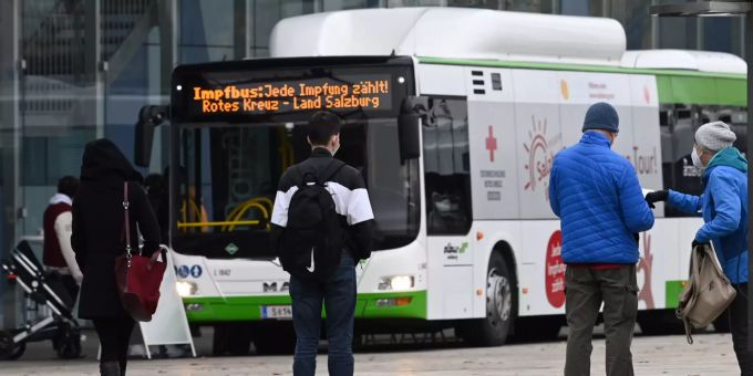 Leute stehen in einer Warteschlange vor einem Impfbus in Salzburg am Montag,15. November 2021. WARTESCHLANGE VOR IMPFBUS