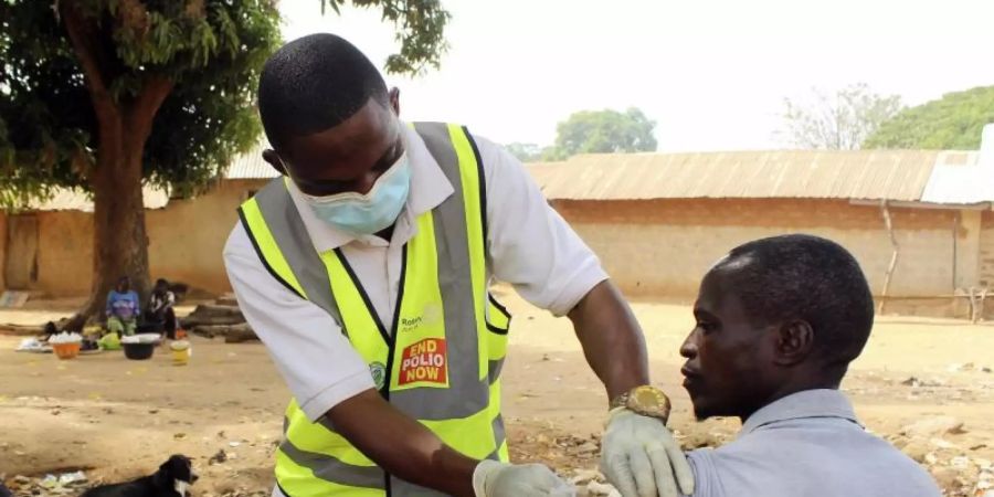 Ein kommunaler Gesundheitshelfer verabreicht einem Mann in Nigeria den Corona-Impfstoff. Foto: Gbemiga Olamikan/AP/dpa