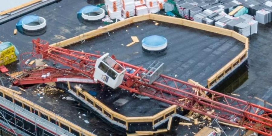 Ein grosser Baukran ist in Neutrabling auf eine Schwimmbad-Baustelle gekippt. Foto: Armin Weigel/dpa