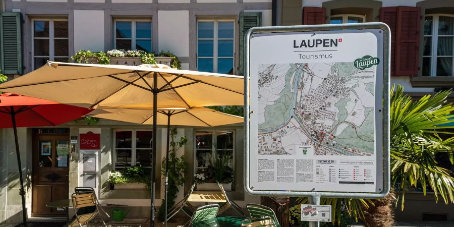 Tafel von Laupen Tourismus mit Sonnenschirmen.