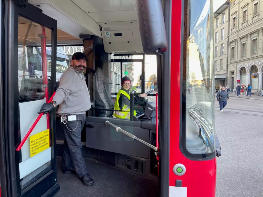 Sarah (11) sitzt für das Bild am Steuer des Bernmobil-Bus, Vater «Mischu» steht daneben.