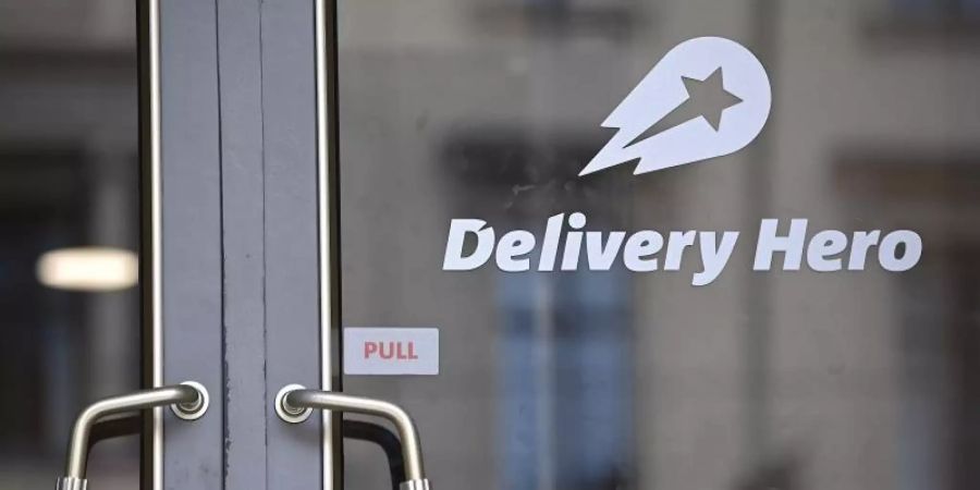 Das Logo Essenslieferdienstes Delivery Hero ist an einer Glasscheibe der Zentrale angebracht. Foto: Britta Pedersen/dpa-Zentralbild/dpa