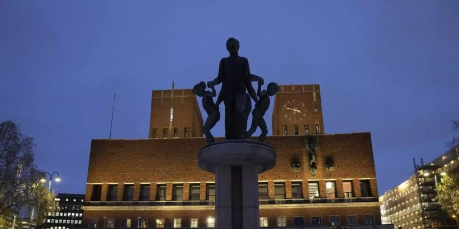 Das Osloer Rathaus ist am Abend beleuchtet. Foto: Alexander Zemlianichenko/AP/dpa