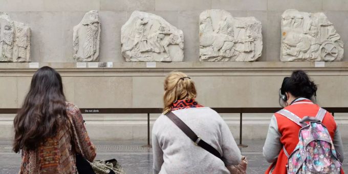 Besucher des British Museum in London sitzen vor Parthenon-Friesteilen. Besucher des British Museum in London sitzen vor Parthenon-Friesteilen