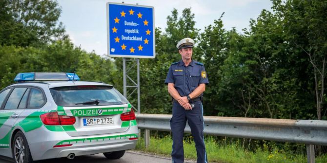 Ein Beamter der bayerischen Grenzpolizei steht am Grenzübergang.