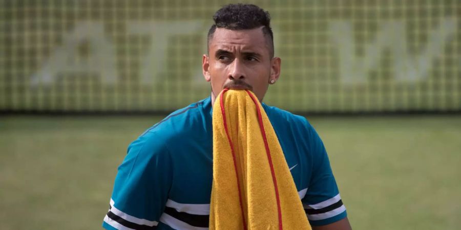 Nick Kyrgios beisst in ein Handtuch.