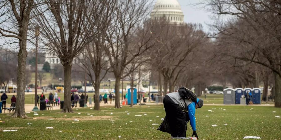 Ein Passant sammelt Müll im National Mall, nahe dem Kapitol, auf.