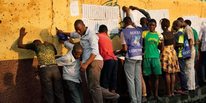Die Opposition unterstellte der Regierung im Kongo einen Manipulationsversuch. Wahlbeamte kleben Wählerlisten an die Wand in Kongo.