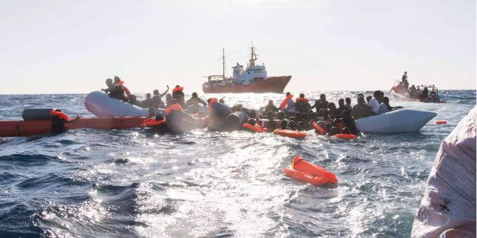 Zahlreiche Flüchtlinge, die auf Booten von Libyen aus nach Italien übersetzen wollten, werden während eines Rettungseinsatzes vor der libyschen Küste geborgen. Im Hintergrund das Rettungsschiff Aquarius. Zahlreiche Flüchtlinge, die auf Booten von Libyen aus nach Italien übersetzen wollten, werden während eines Rettungseinsatzes vor der libyschen Küste geborgen. Im Hintergrund das Rettungsschiff Aquarius.