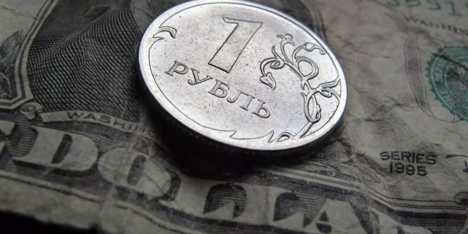 Eine russische Ein-Rubel-Münze liegt auf einer amerikanischen Ein-Dollar-Note. Rubel