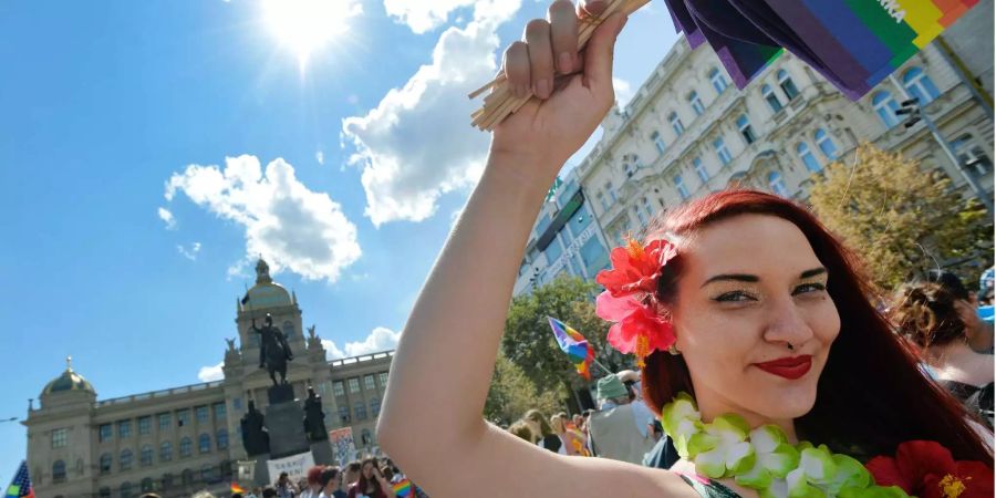 Eine Teilnehmerin des Prague-Pride-Festivals hat eine Regenbogenfahne in der Hand.