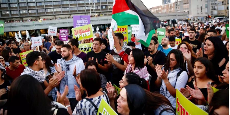 Arabische Israelis halten während den Protesten eine Palestina-Flagge hoch.