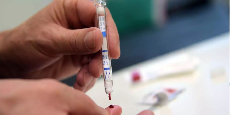 Ein Mann führt einen HIV-Heimtest durch.