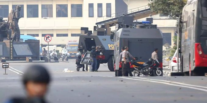 Polizisten nehmen hinter einem gepanzerten Fahrzeug am Hauptquartier der Mobile Brigade Position ein. indonesien