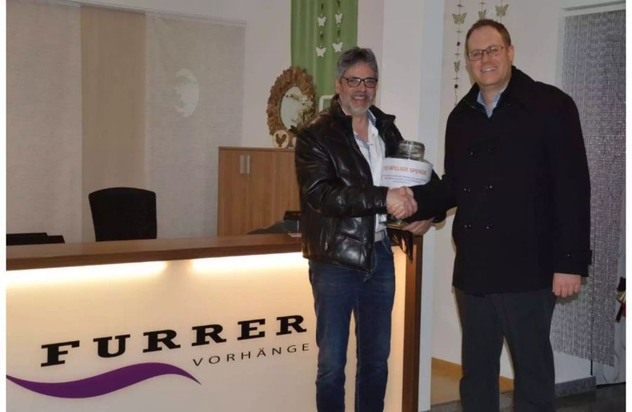 Urs Breitenmoser, Geschäftsführer der Furrer Vorhänge AG, übergibt Gemeindepräsident Philipp Scheuble die Spende für die Winterhilfe.